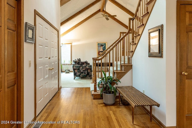 foyer entrance featuring high vaulted ceiling, light wood-type flooring, and beamed ceiling