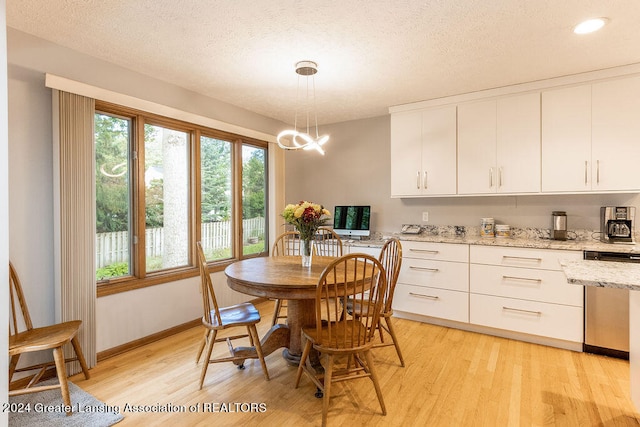 dining room with a textured ceiling and light hardwood / wood-style floors