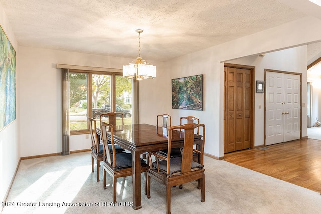 dining area featuring an inviting chandelier, a textured ceiling, and hardwood / wood-style flooring