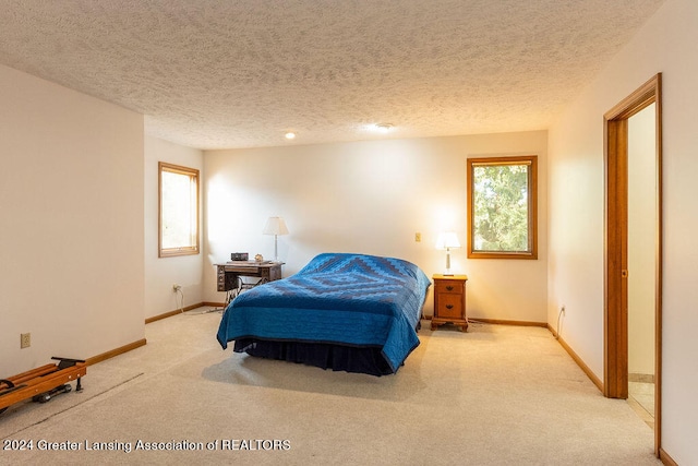 bedroom with a textured ceiling and light carpet