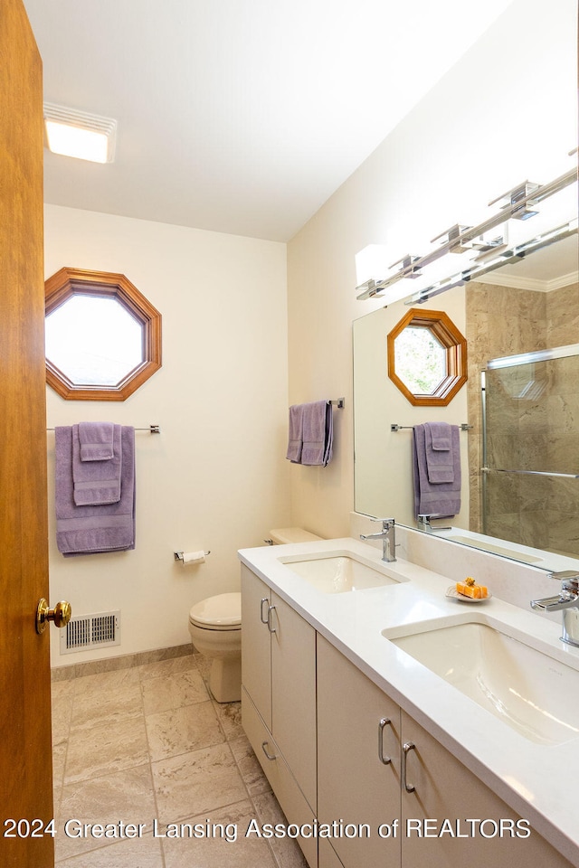 bathroom featuring vanity, toilet, and a shower with door