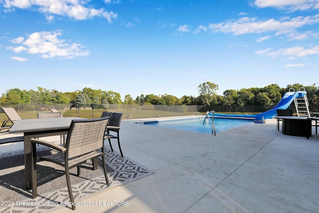 view of swimming pool featuring a patio and a water slide