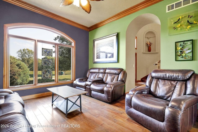 living room with ceiling fan, a textured ceiling, light hardwood / wood-style flooring, and crown molding