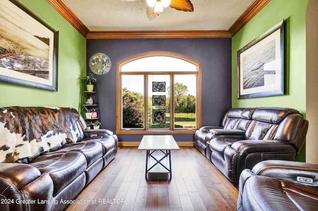 living room with wood-type flooring, ceiling fan, crown molding, and a textured ceiling