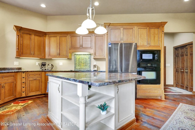 kitchen featuring pendant lighting, black appliances, hardwood / wood-style flooring, and dark stone counters