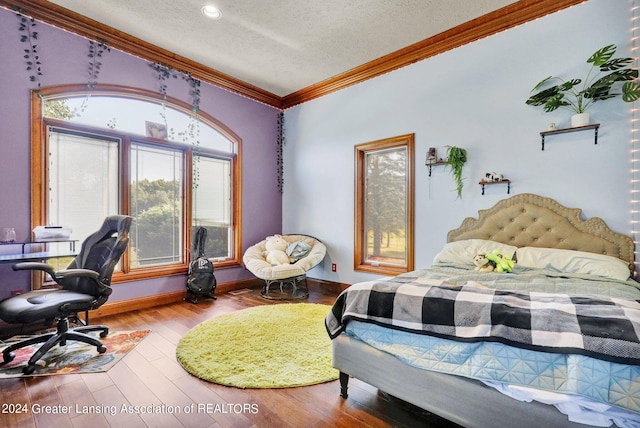 bedroom featuring a textured ceiling, crown molding, and hardwood / wood-style floors