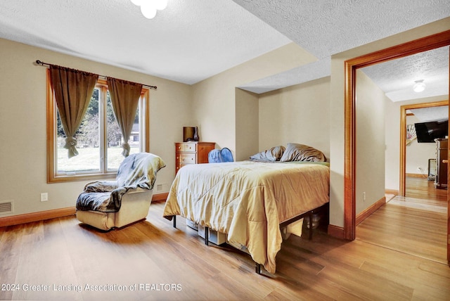 bedroom with a textured ceiling and hardwood / wood-style flooring