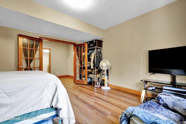 bedroom with hardwood / wood-style flooring and a textured ceiling