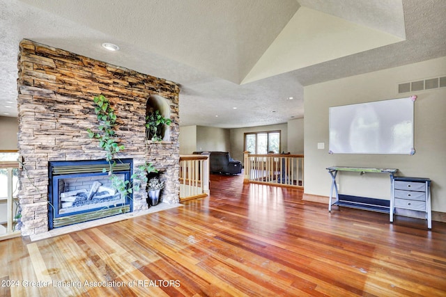 unfurnished living room with a textured ceiling, a fireplace, and hardwood / wood-style floors