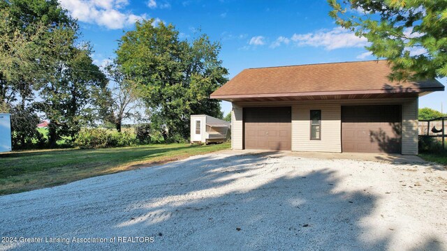 exterior space featuring an outdoor structure, a garage, and a front lawn