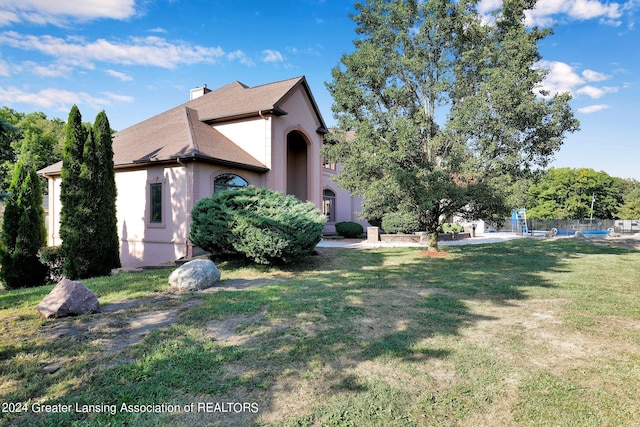 view of side of home with a lawn