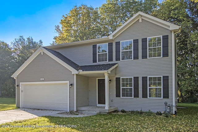 view of front of property with a front yard and a garage