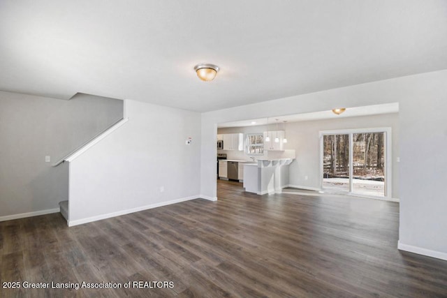 unfurnished living room with dark wood-type flooring