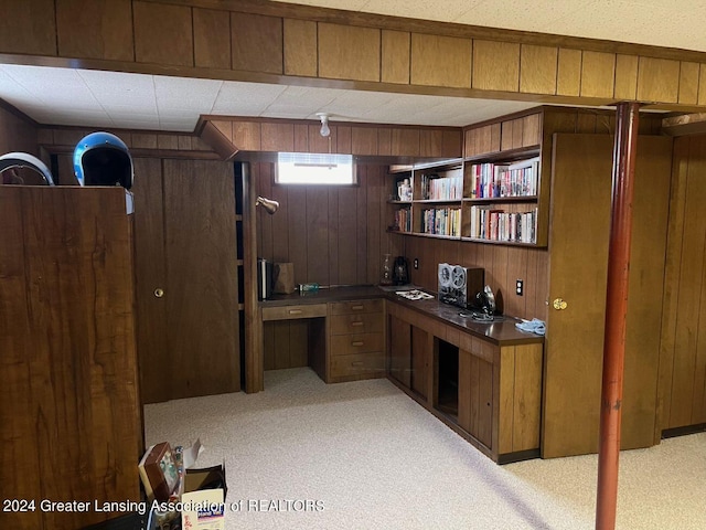 office space featuring wood walls and light colored carpet