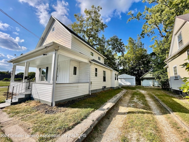 view of property exterior with covered porch and a yard