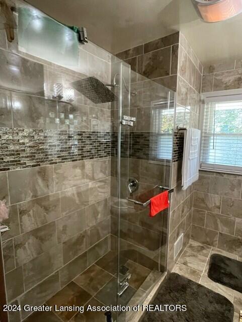 bathroom featuring a shower with shower door