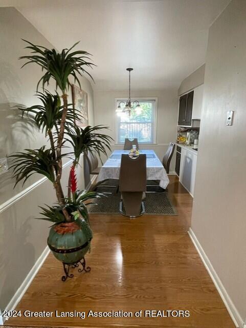 dining area featuring a notable chandelier and dark wood-type flooring