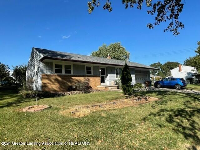 single story home featuring a front yard and a garage