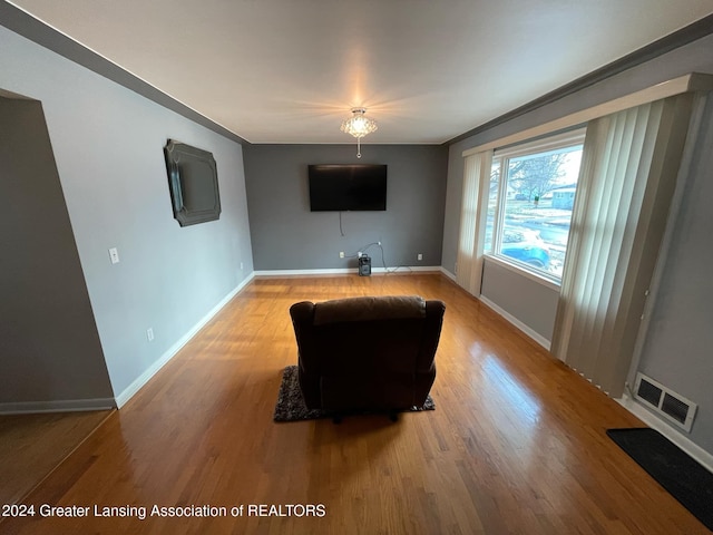 unfurnished living room featuring crown molding and hardwood / wood-style floors