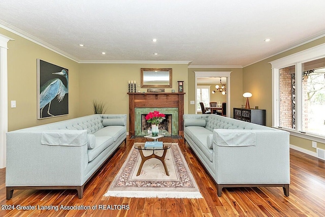 living room featuring ornamental molding, hardwood / wood-style flooring, and a notable chandelier