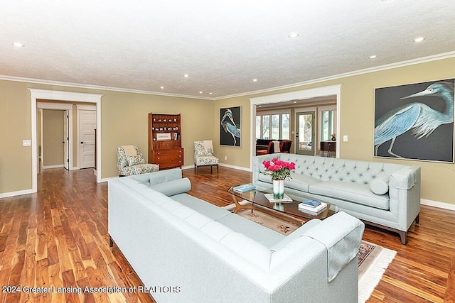 living room featuring a textured ceiling, wood-type flooring, and ornamental molding