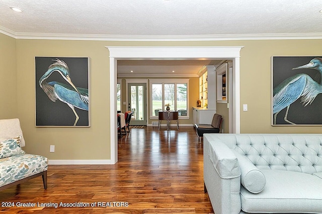 living room featuring a textured ceiling, dark hardwood / wood-style floors, and ornamental molding