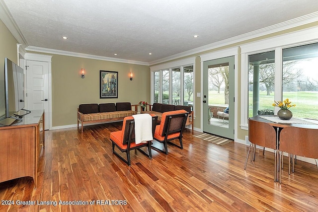 living room featuring a textured ceiling, wood-type flooring, and crown molding