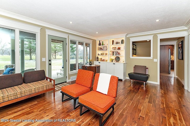 living room featuring a textured ceiling, hardwood / wood-style flooring, and crown molding