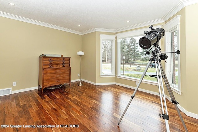 exercise area with a textured ceiling, crown molding, and dark hardwood / wood-style flooring