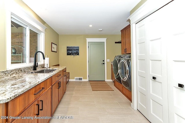 washroom featuring separate washer and dryer, cabinets, and sink