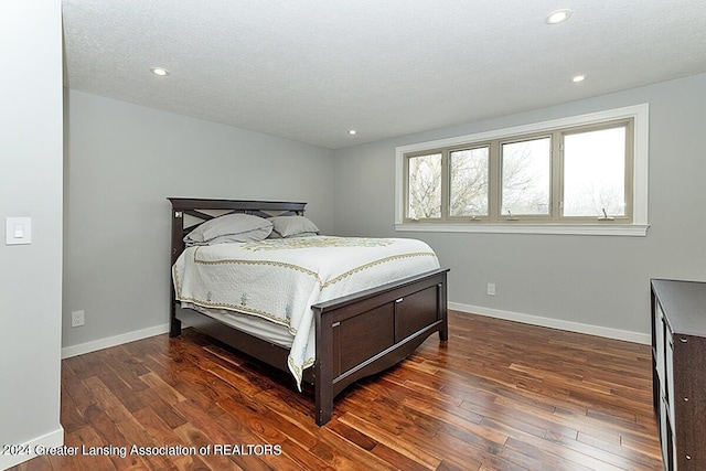 bedroom featuring a textured ceiling and dark hardwood / wood-style flooring