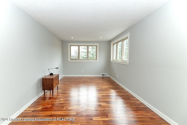 empty room featuring wood-type flooring and a textured ceiling