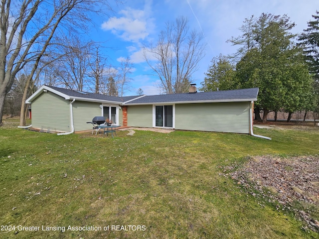 rear view of house with a lawn and a patio area