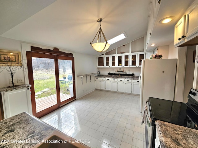 kitchen with white cabinets, pendant lighting, light tile patterned floors, lofted ceiling with skylight, and electric range