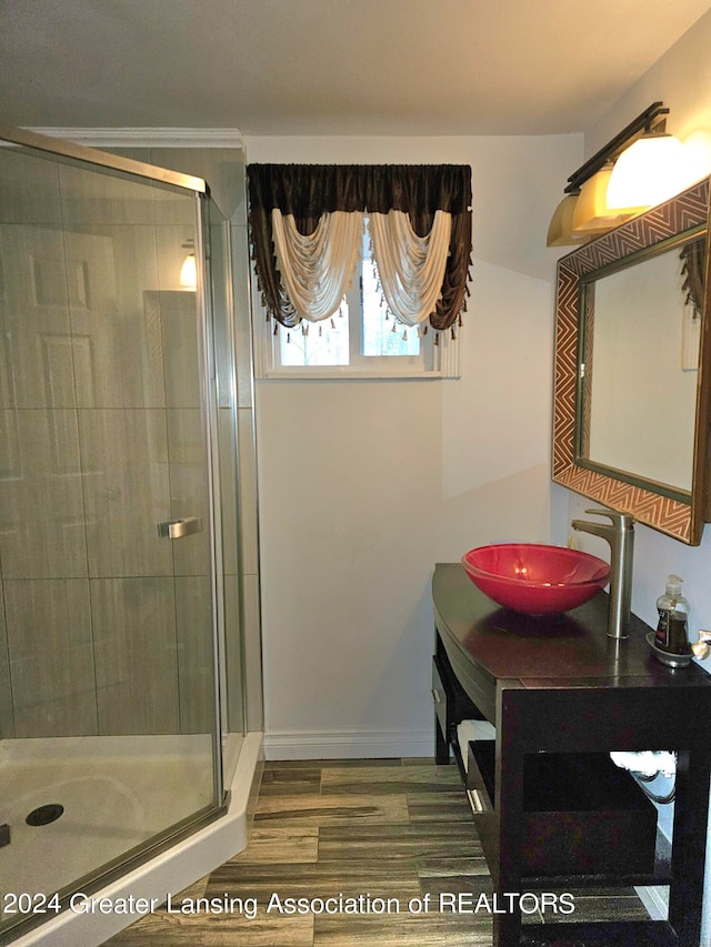 bathroom with walk in shower, vanity, and hardwood / wood-style floors