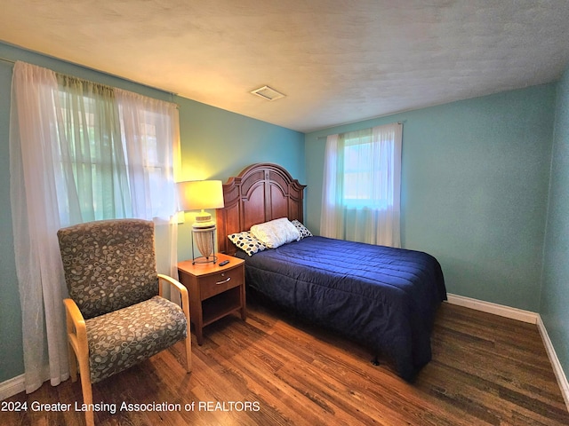 bedroom with dark hardwood / wood-style flooring