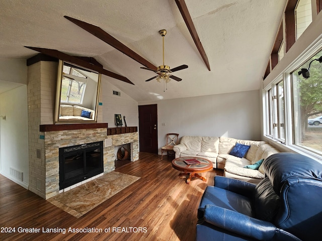 living room featuring a textured ceiling, a fireplace, lofted ceiling with beams, and dark hardwood / wood-style flooring