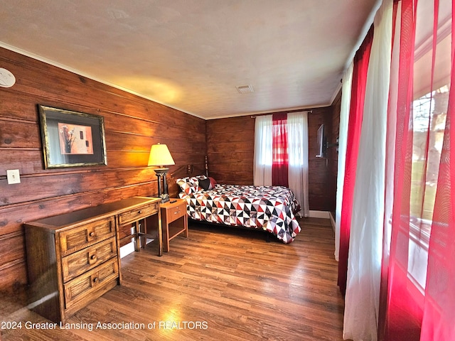 bedroom featuring wooden walls and hardwood / wood-style floors