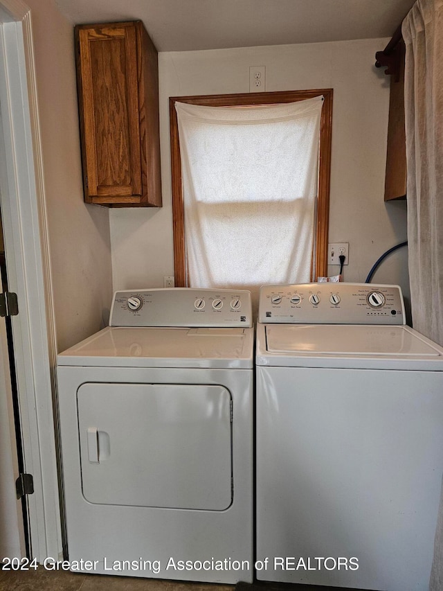 laundry room with washing machine and clothes dryer and cabinets