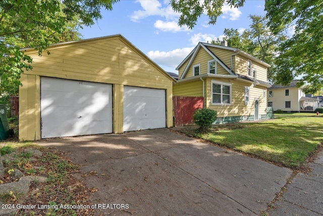 front of property featuring a garage, a front lawn, and an outbuilding