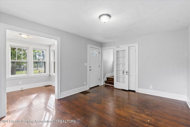 unfurnished bedroom with a textured ceiling and dark hardwood / wood-style flooring