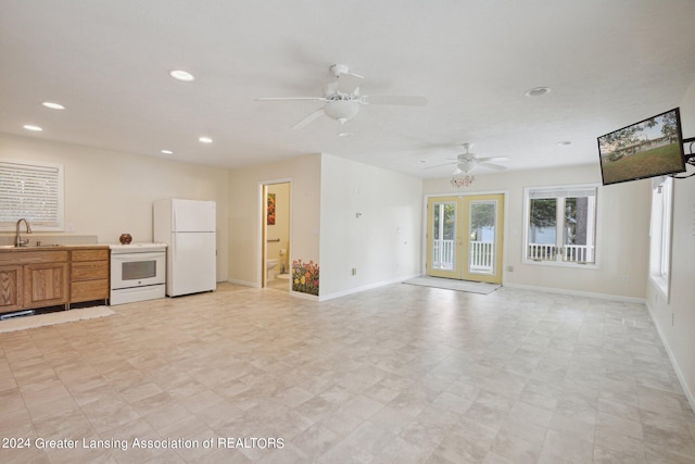 unfurnished living room featuring ceiling fan, french doors, and sink