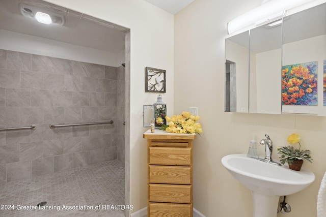 bathroom featuring tiled shower and sink