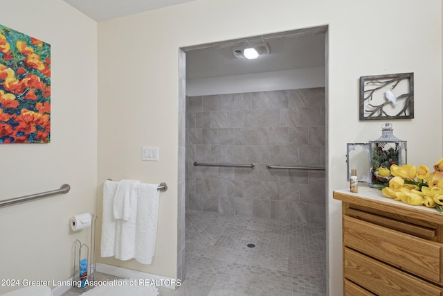 bathroom featuring a tile shower and vanity