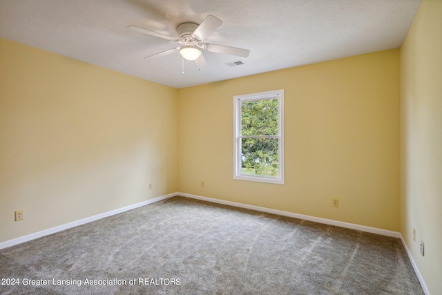 empty room featuring ceiling fan and carpet