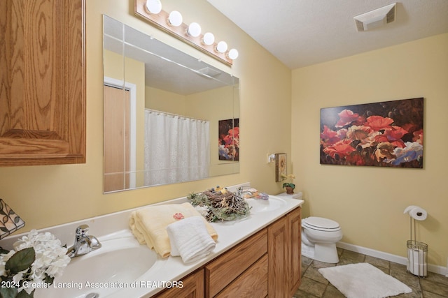 bathroom featuring vanity, tile patterned flooring, and toilet