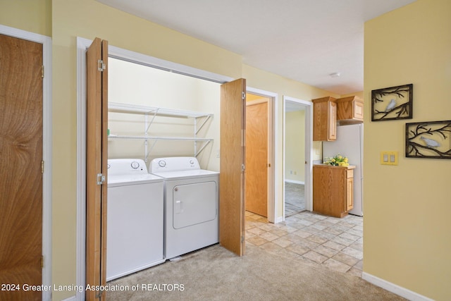 clothes washing area with light carpet and washer and clothes dryer