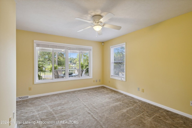 carpeted spare room with ceiling fan