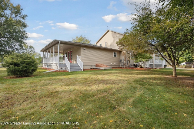 rear view of property with a lawn