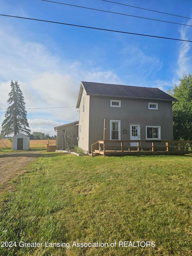 view of front of home with a storage unit and a front lawn